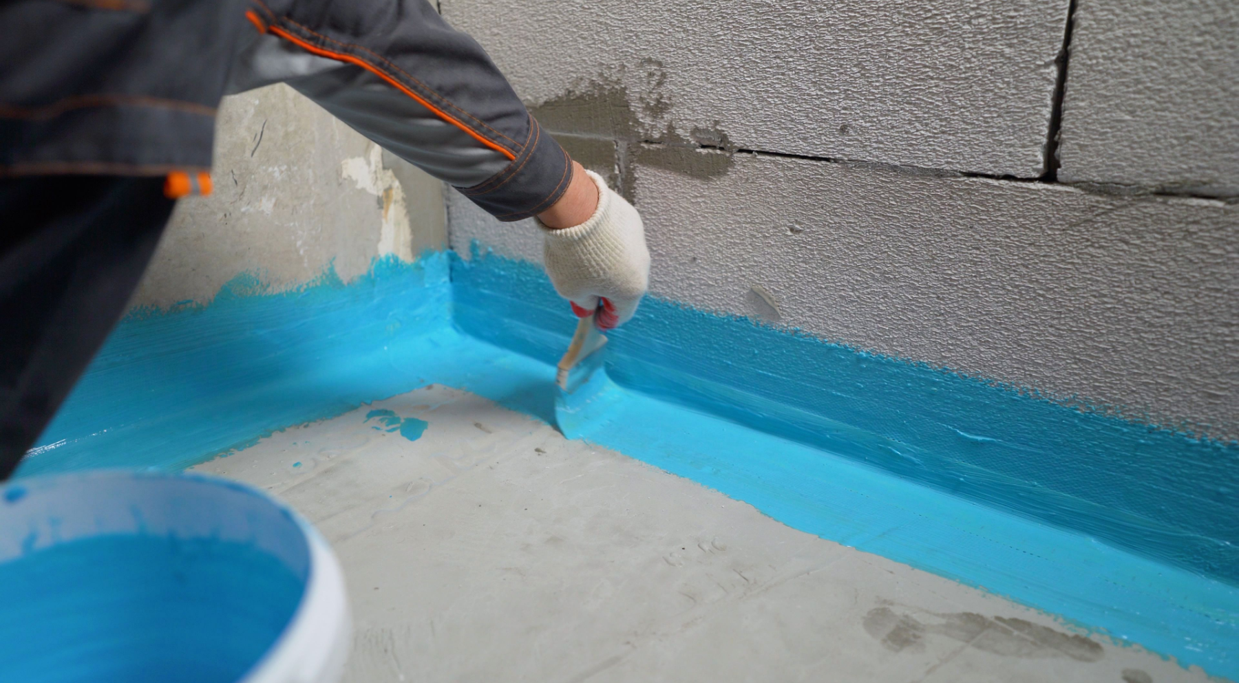 Una persona está pintando una pared con pintura azul.