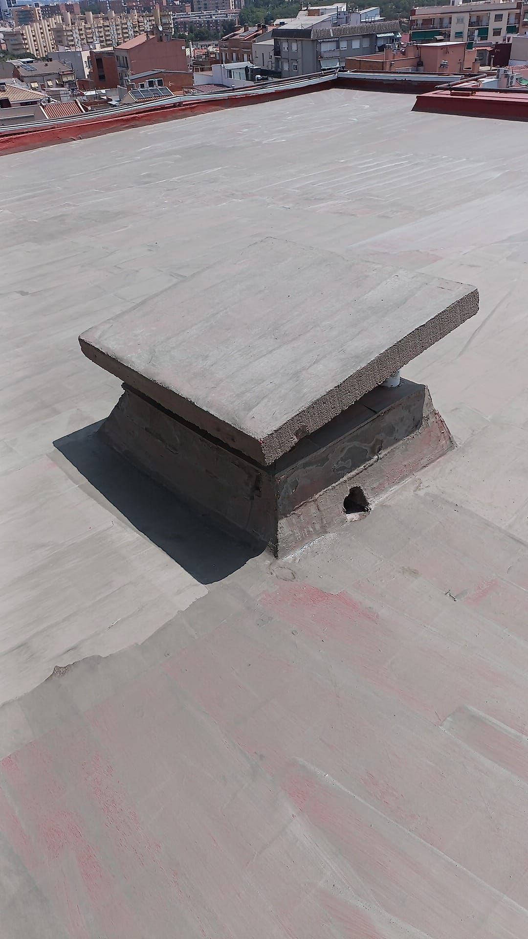 Un trozo de hormigón está colocado encima de un tejado de hormigón.
