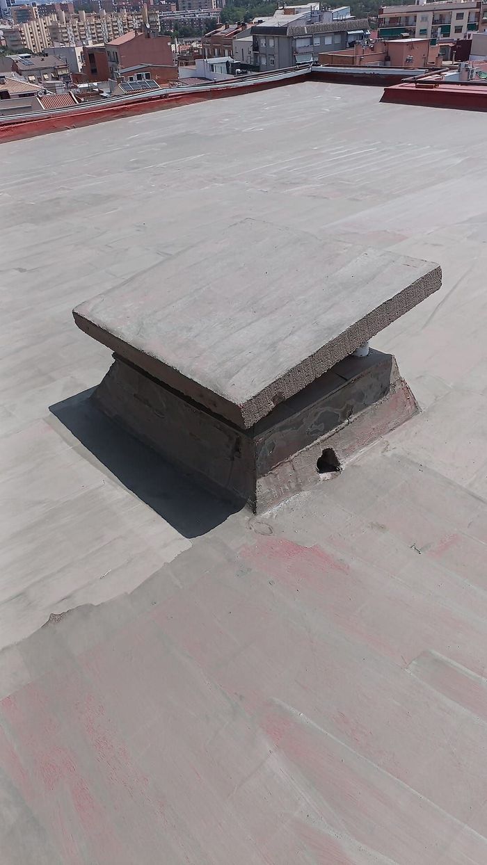 Un trozo de hormigón está colocado encima de un tejado de hormigón.