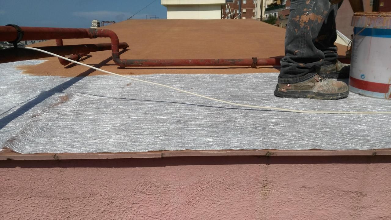 Una persona está parada en un tejado con una lata de pintura.