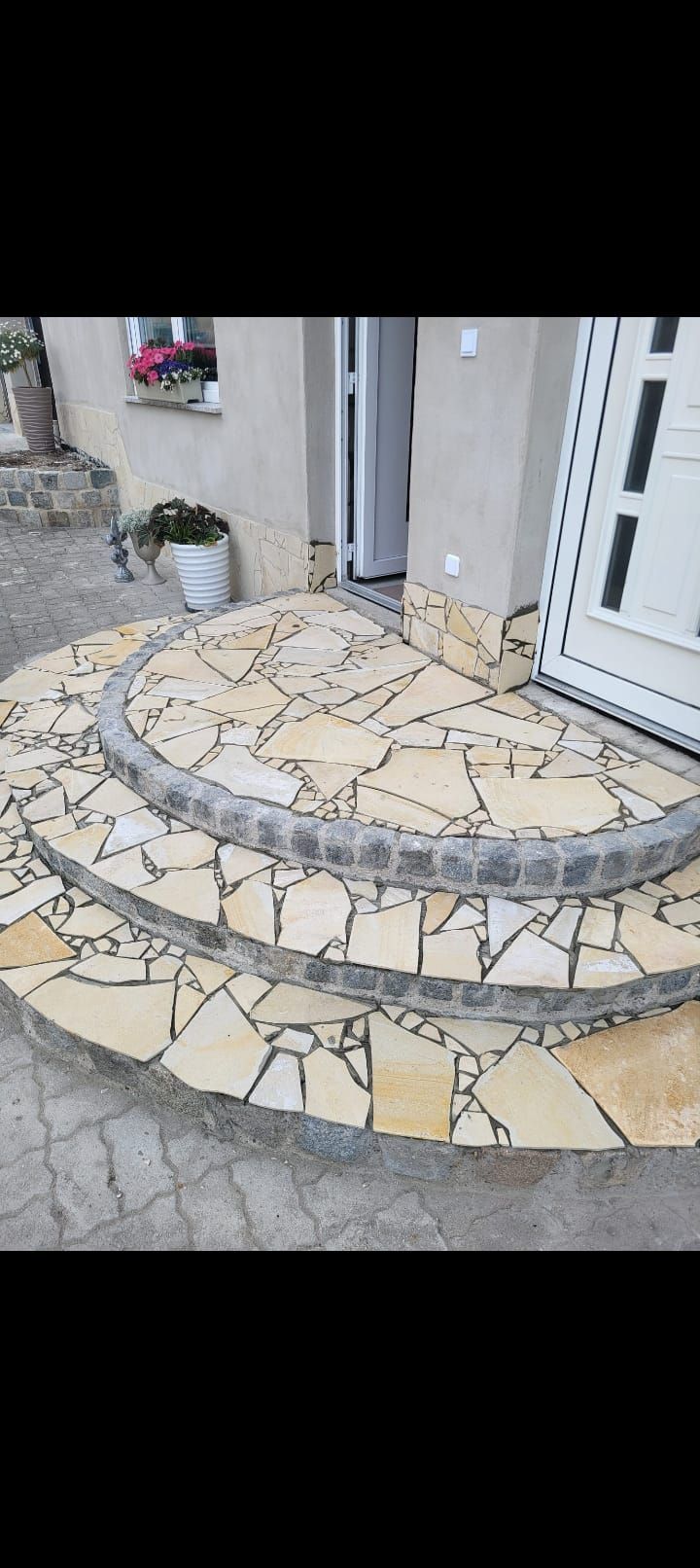 Steinstufen führen zu einem Hauseingang. 