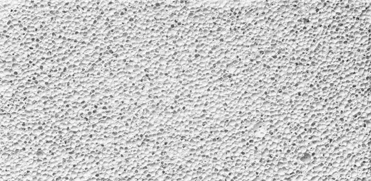 Nahaufnahme einer weißen, strukturierten Oberfläche, möglicherweise Stuck oder Beton.