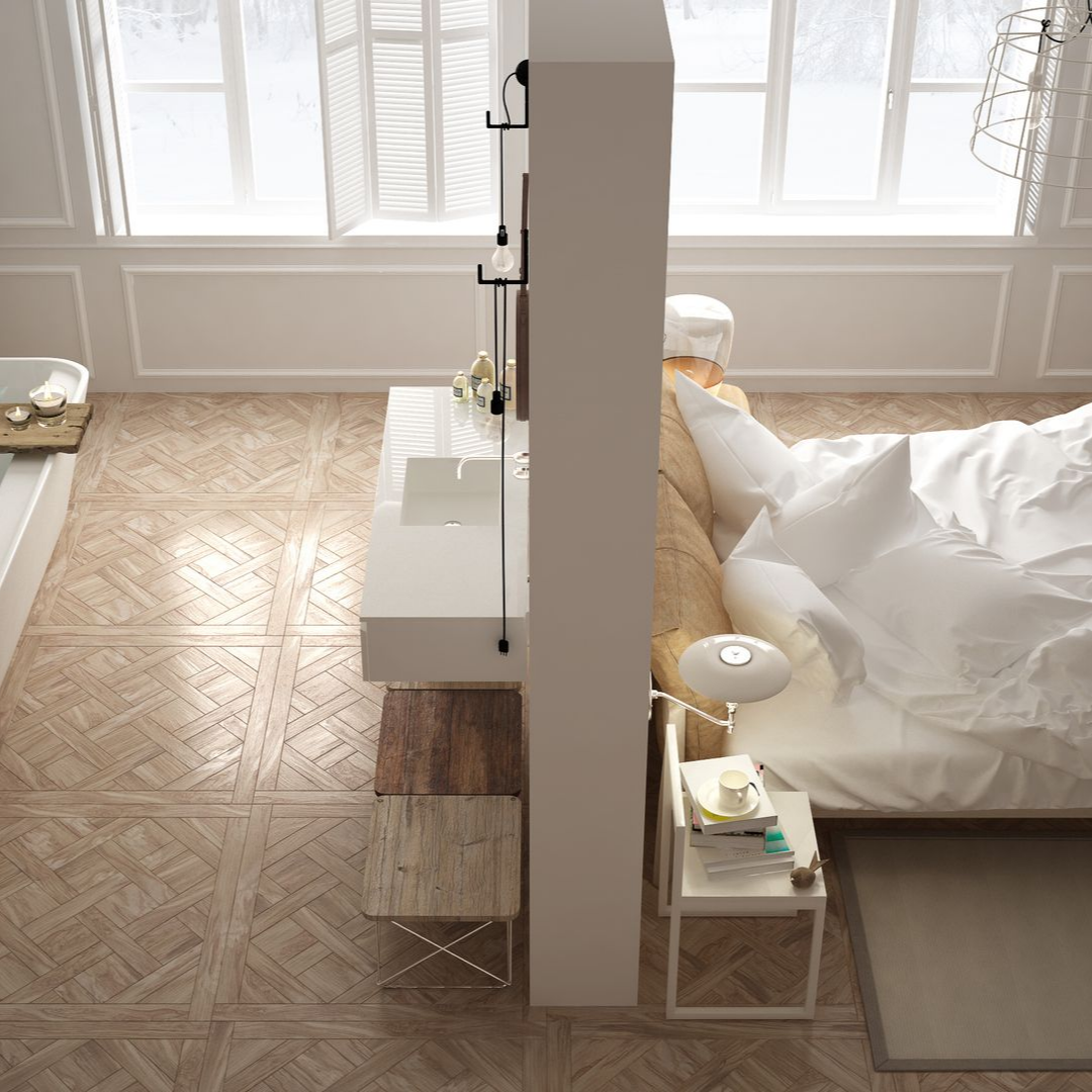 Une chambre et une salle de bains séparées par une cloison centrale, avec un lit d'un côté et un lavabo moderne de l'autre.