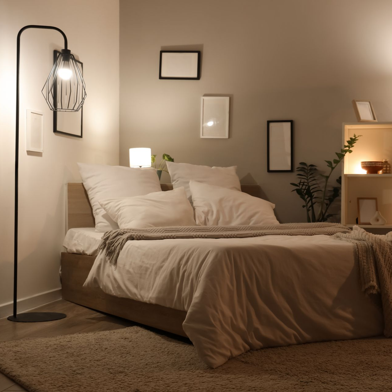 Une chambre confortable comprend un lit avec des draps blancs, un grand lampadaire, une étagère de chevet.