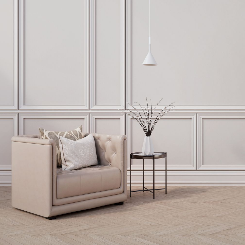 Un fauteuil beige capitonné avec des coussins à motifs.