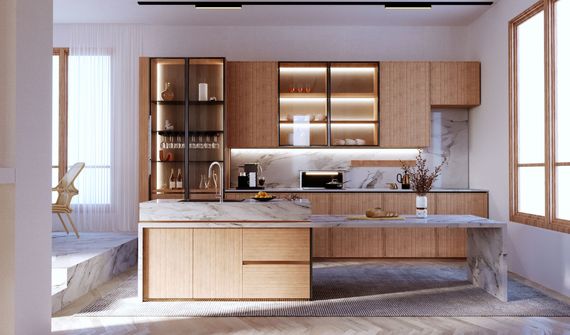 Cuisine moderne avec armoires en bois clair, comptoirs en marbre blanc et éclairage chaleureux sous les armoires.