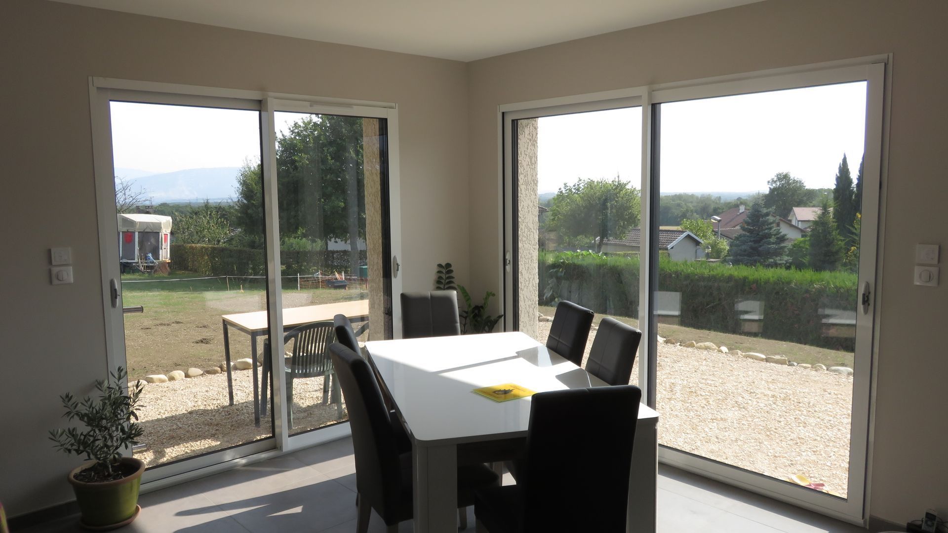 Dans une pièce lumineuse, une table à manger et des chaises sont disposées.
