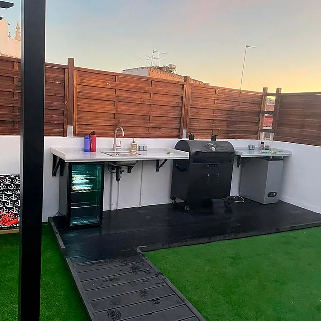 Hay una parrilla y un fregadero en el patio trasero.