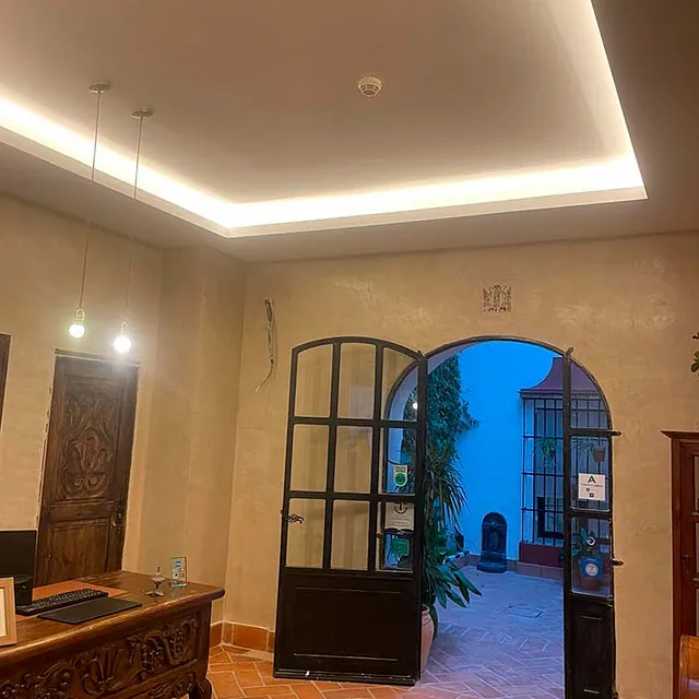 Una habitación con un escritorio, una puerta y una lámpara de techo.