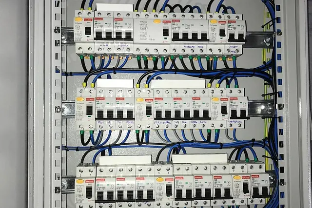 Un primer plano de una caja eléctrica con muchos cables saliendo de ella.