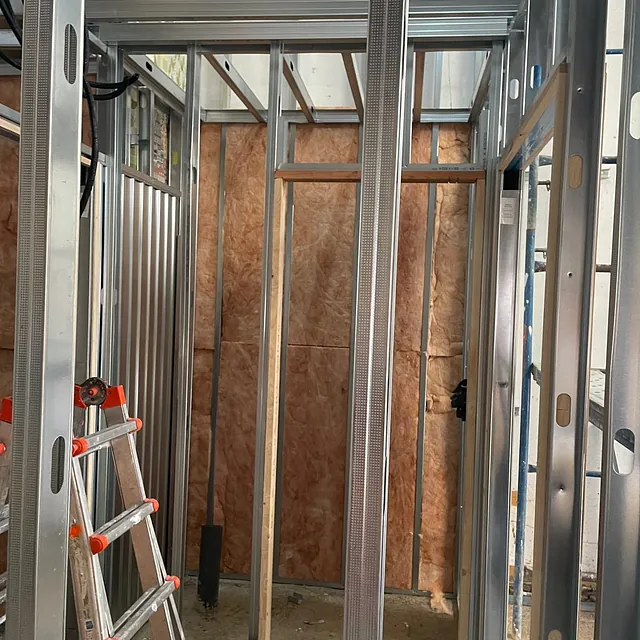 Una escalera está en el medio de una habitación en construcción.