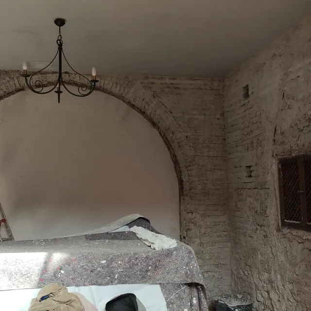 Una habitación con una pared de ladrillos y una lámpara de araña colgando del techo.