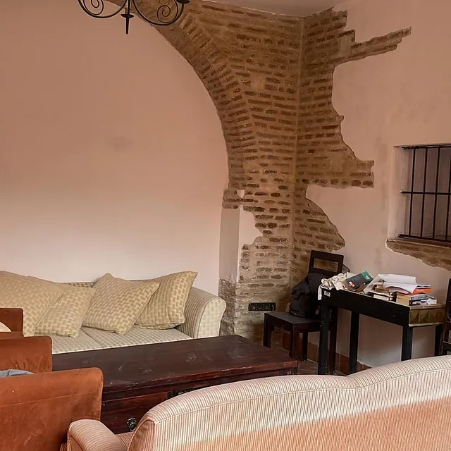 Una sala de estar con muebles y una pared de ladrillos.