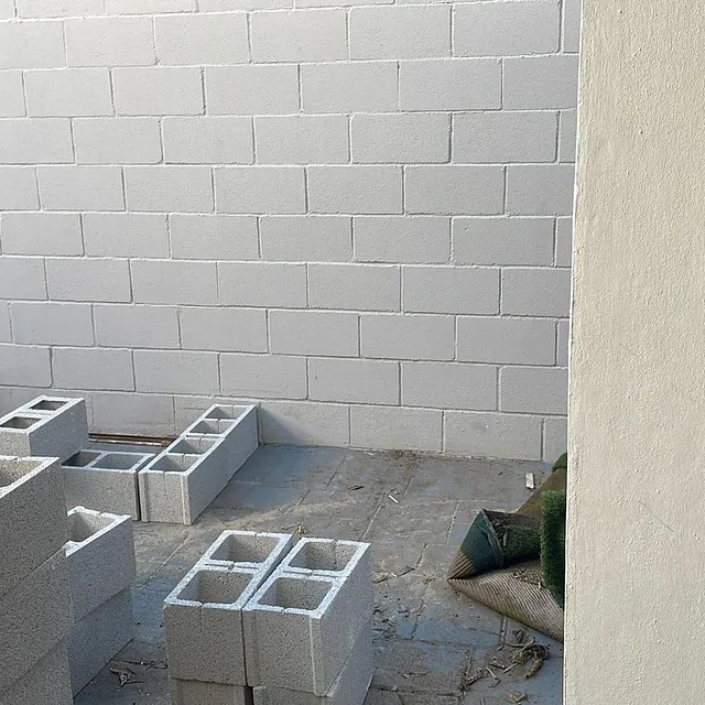 Una pared de ladrillos blancos con muchos bloques delante de ella.