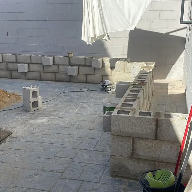Se está construyendo un muro de ladrillos en un patio trasero.