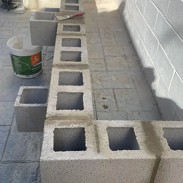 Un cubo de Gatorade se encuentra junto a una fila de bloques de hormigón.