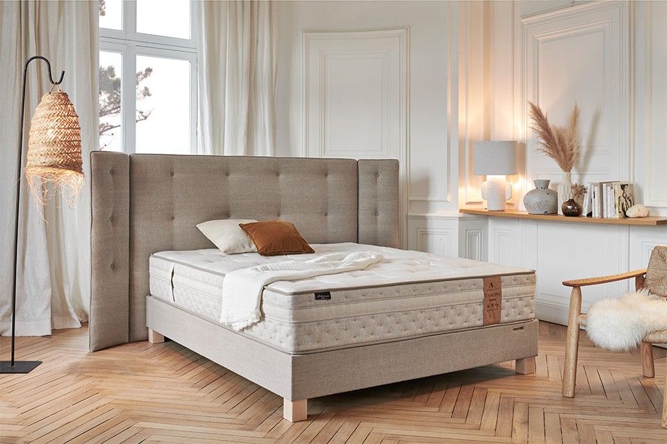 Chambre moderne avec matelas de marque André Renault et tête de lit grise