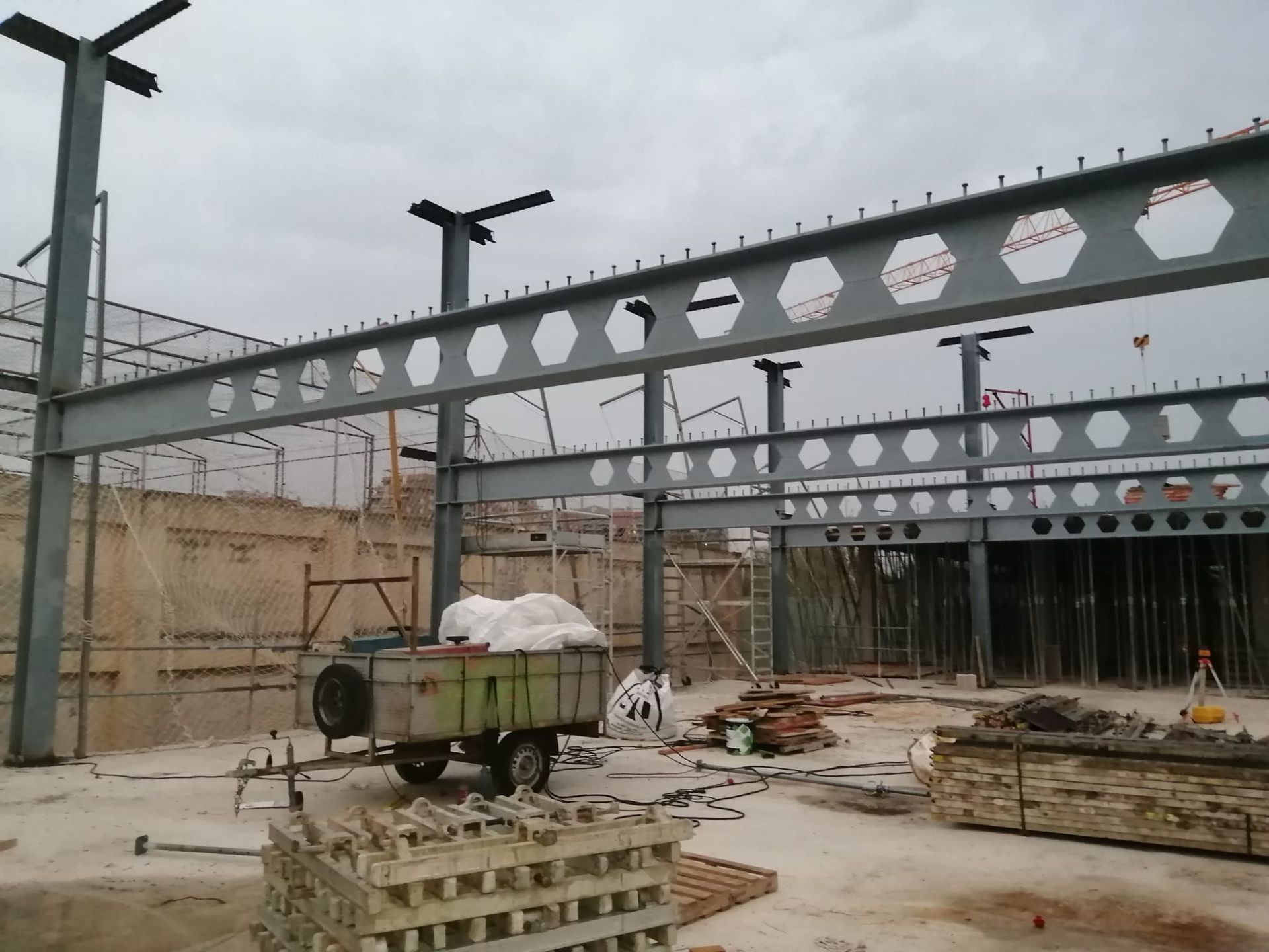 Un sitio de construcción con un remolque verde lleno de ladrillos