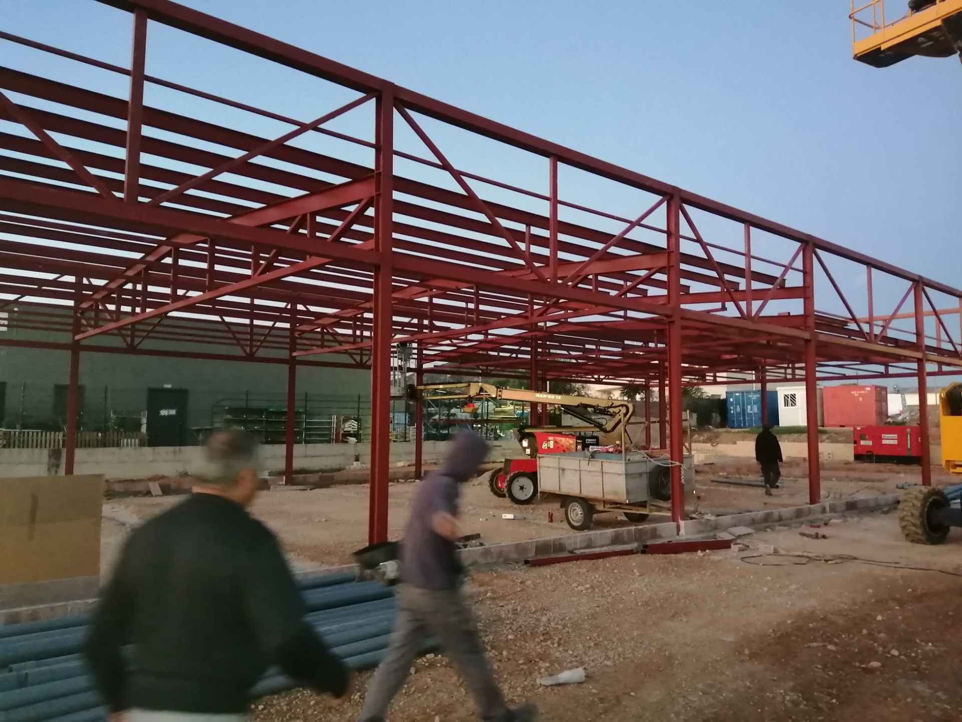 Un hombre camina frente a una gran estructura metálica.