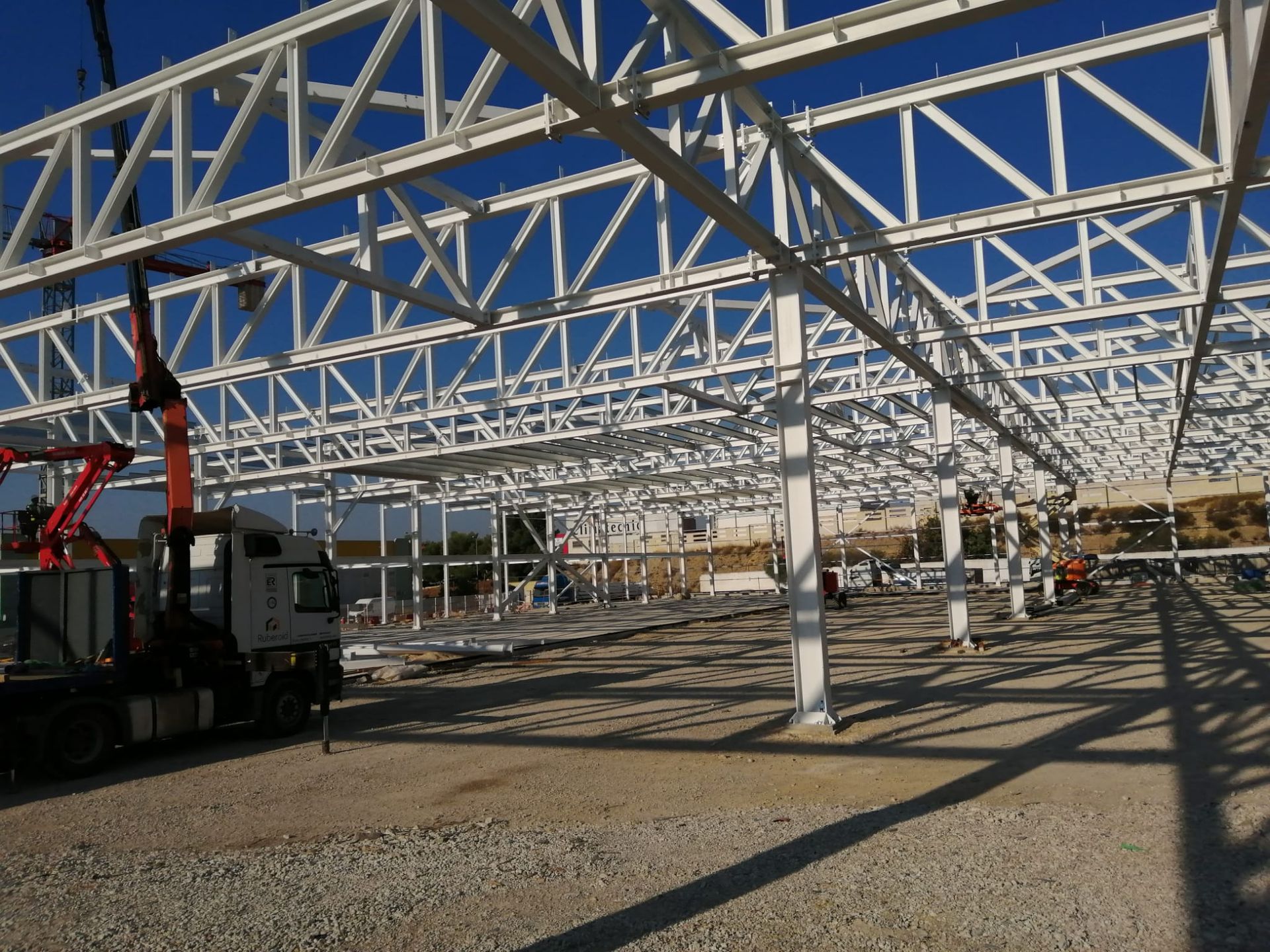 Una gran estructura metálica en construcción con un camión en primer plano.