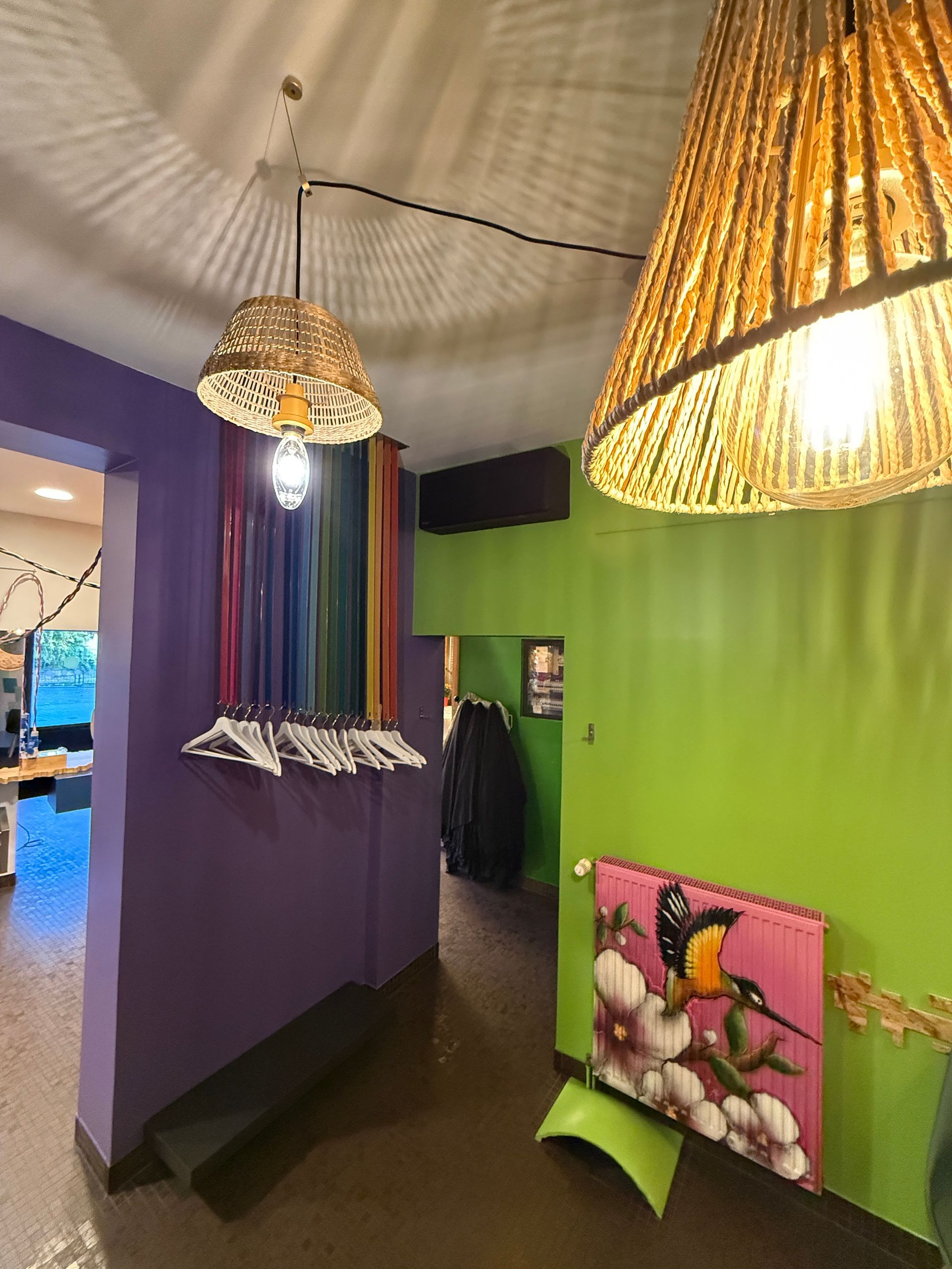 Vue sur le dressing composé de cintres accrochés à des bandes en plastique coloré
