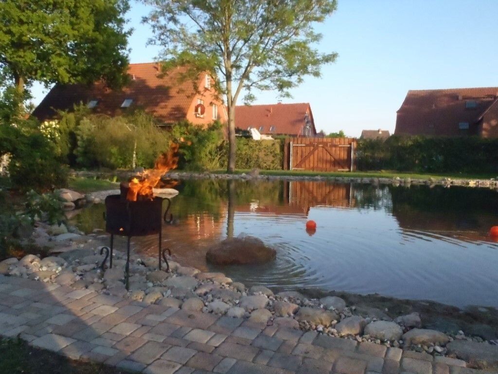 Schwimmteich am Abend mit Feuerschale