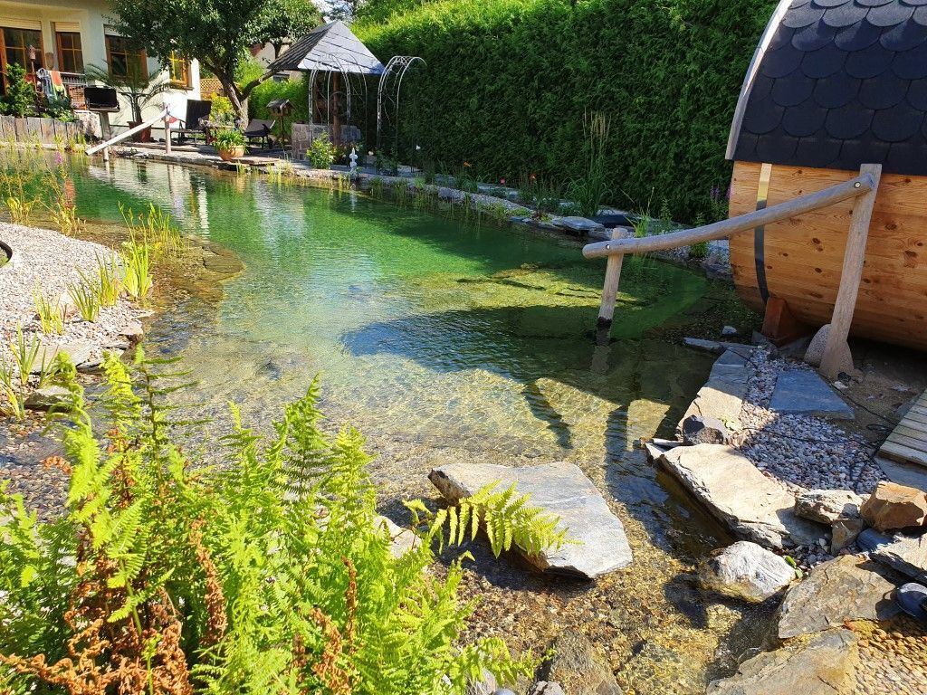 Mittelgroßer Schwimmteich mit Fasssauna