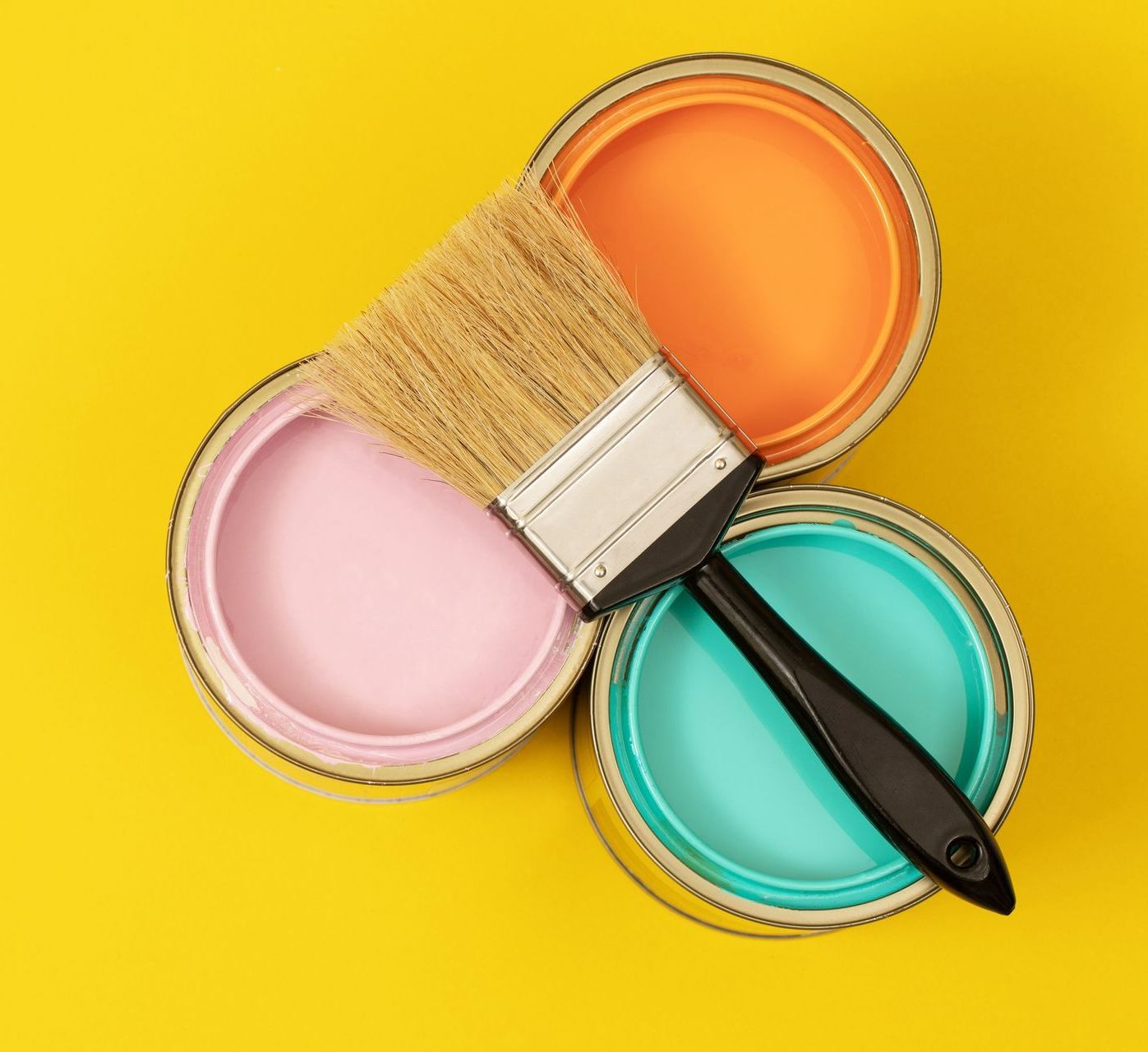 Trois pots de peinture avec un pinceau
