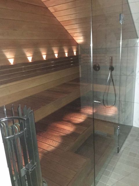 Nybyggnation och renovering av fritidshus och bastur. Modern bastu med glasvägg och träpanel.
