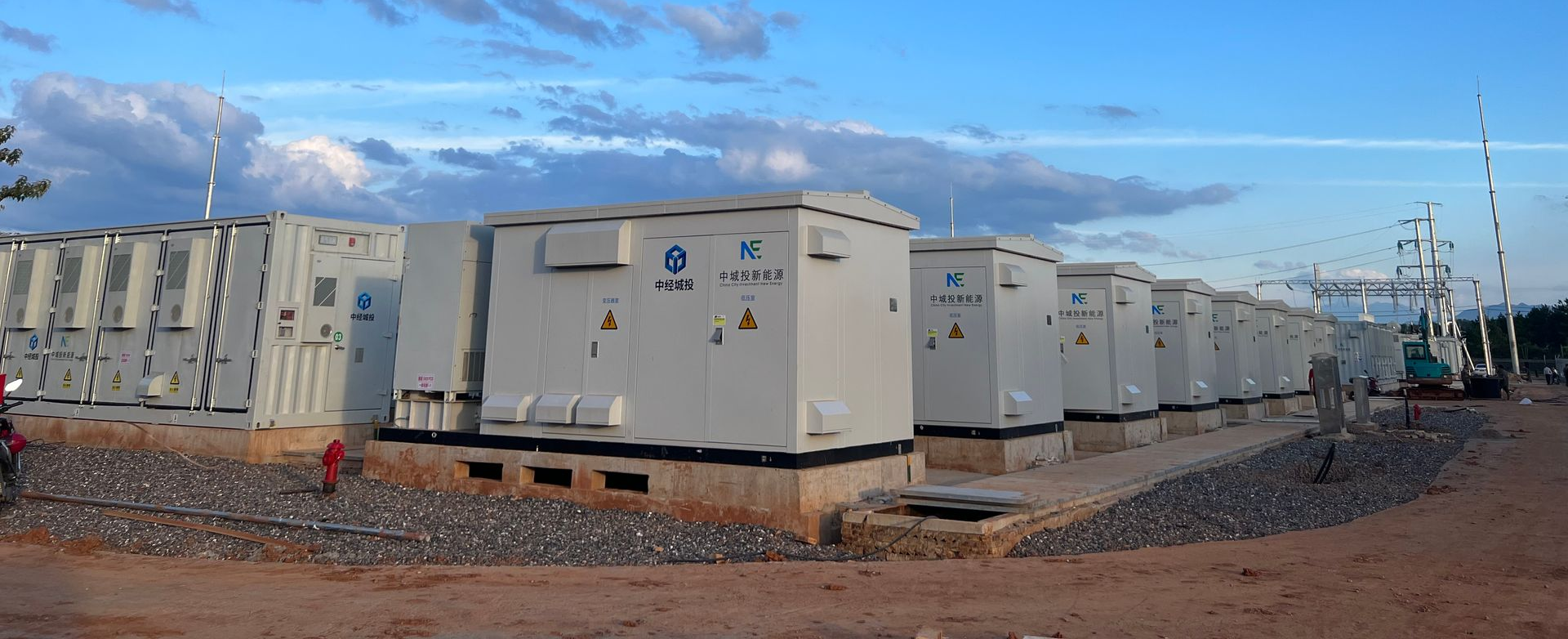 Équipements électriques extérieurs, alignés sur un ciel nuageux.