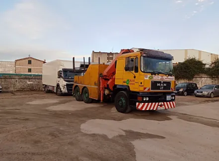 Una grúa amarilla está estacionada en un estacionamiento.