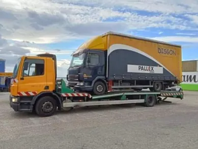 Una grúa amarilla transporta un camión amarillo grande.