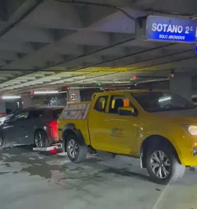 Un camión amarillo está estacionado debajo de un cartel que dice sótano.