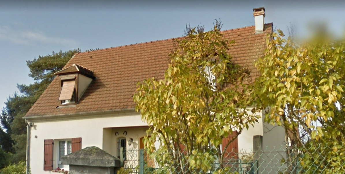 Une maison derrière un arbre