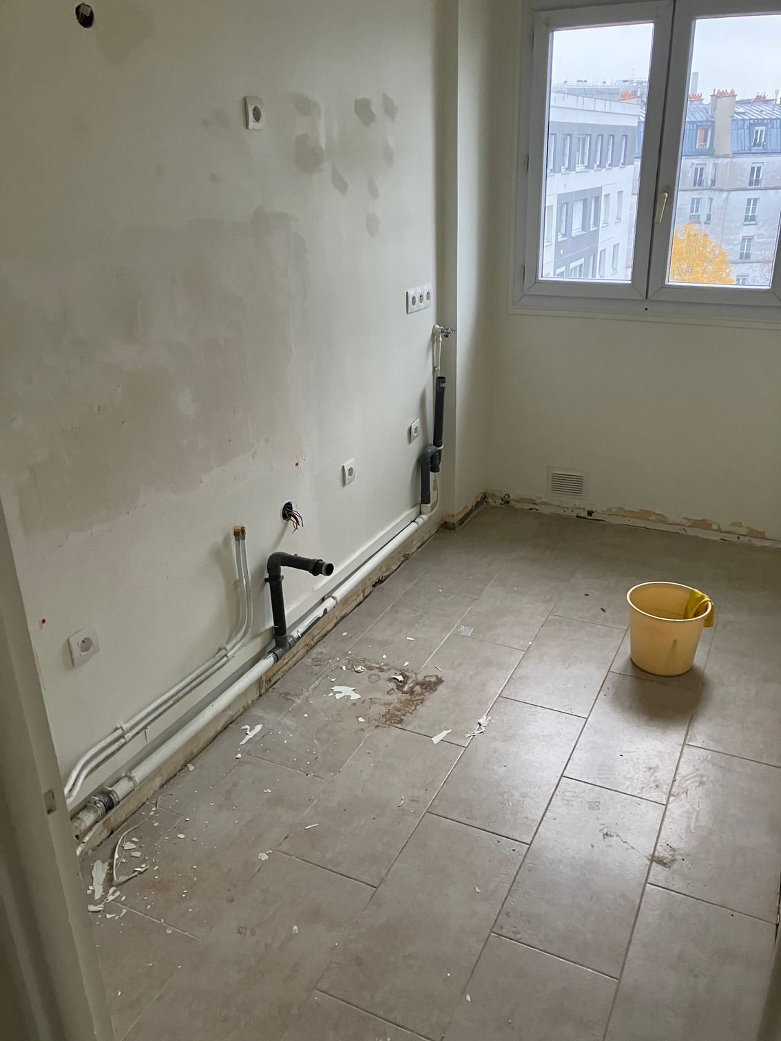 Un seau jaune sur du carrelage