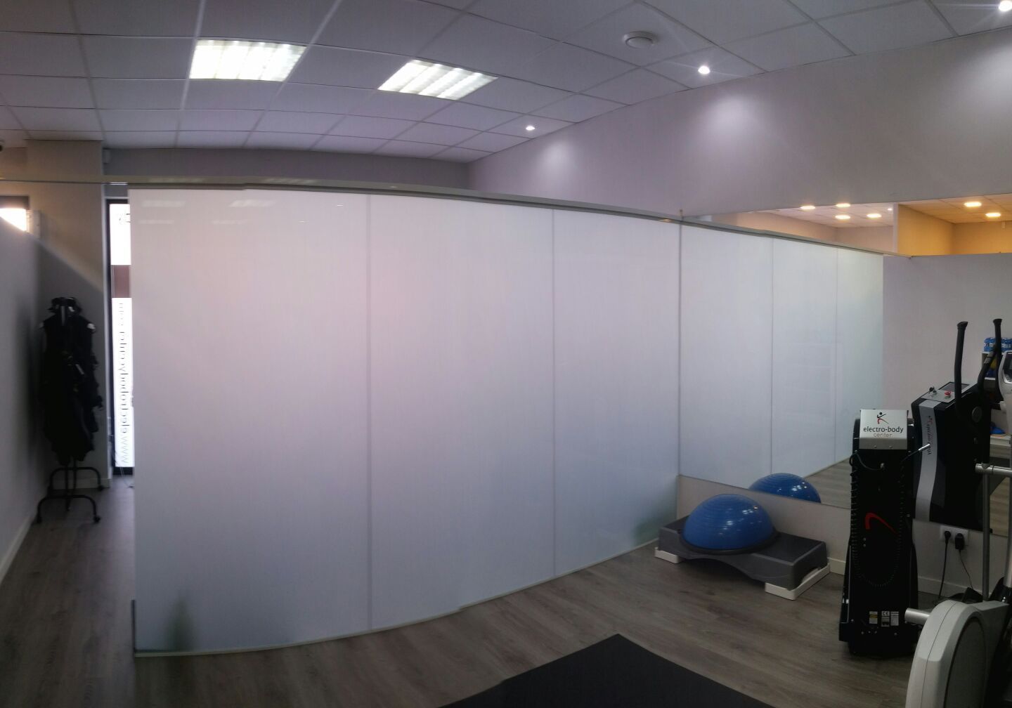 Un gimnasio con una pared blanca y un espejo.