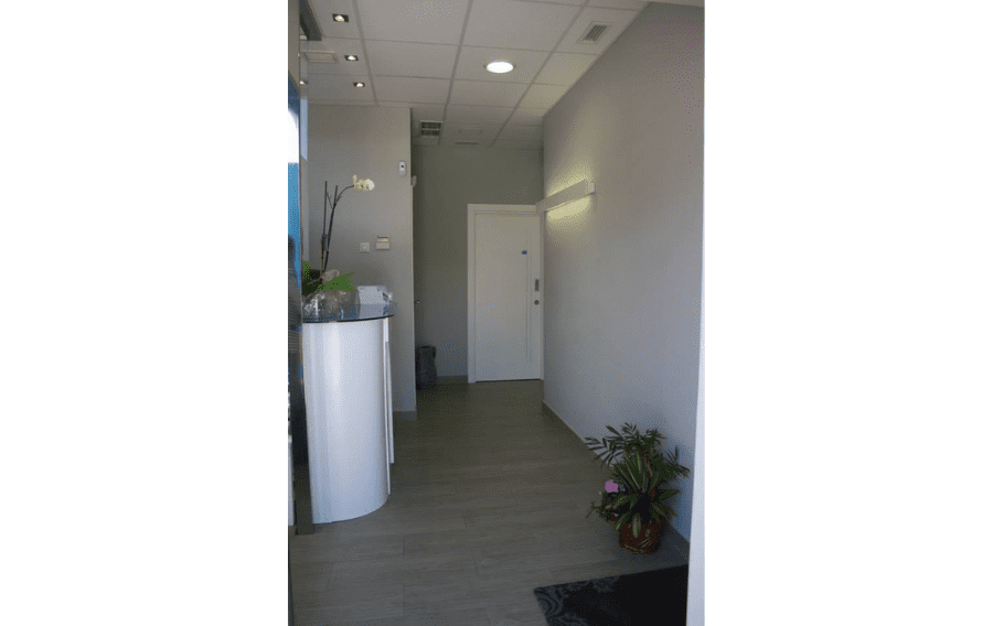 Un pasillo con un mostrador blanco y una puerta blanca.