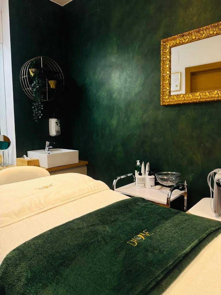 Hay una cama con una toalla verde encima en una habitación con una pared verde.