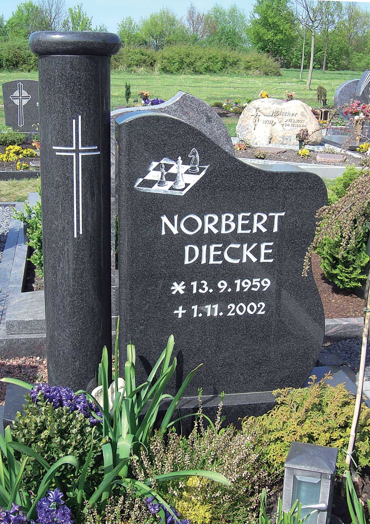individueller Grabstein mit Beschriftung und Kreuz- und Schachbrett-Verzierung