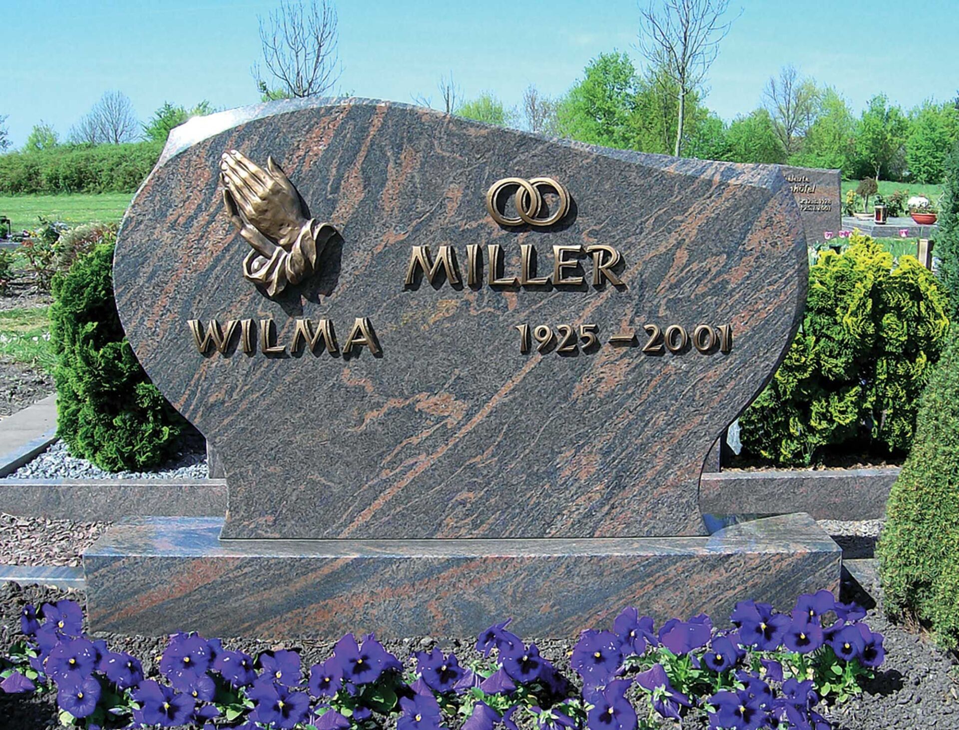 Grabstein mit gefalteten Händen verziert und Beschriftung