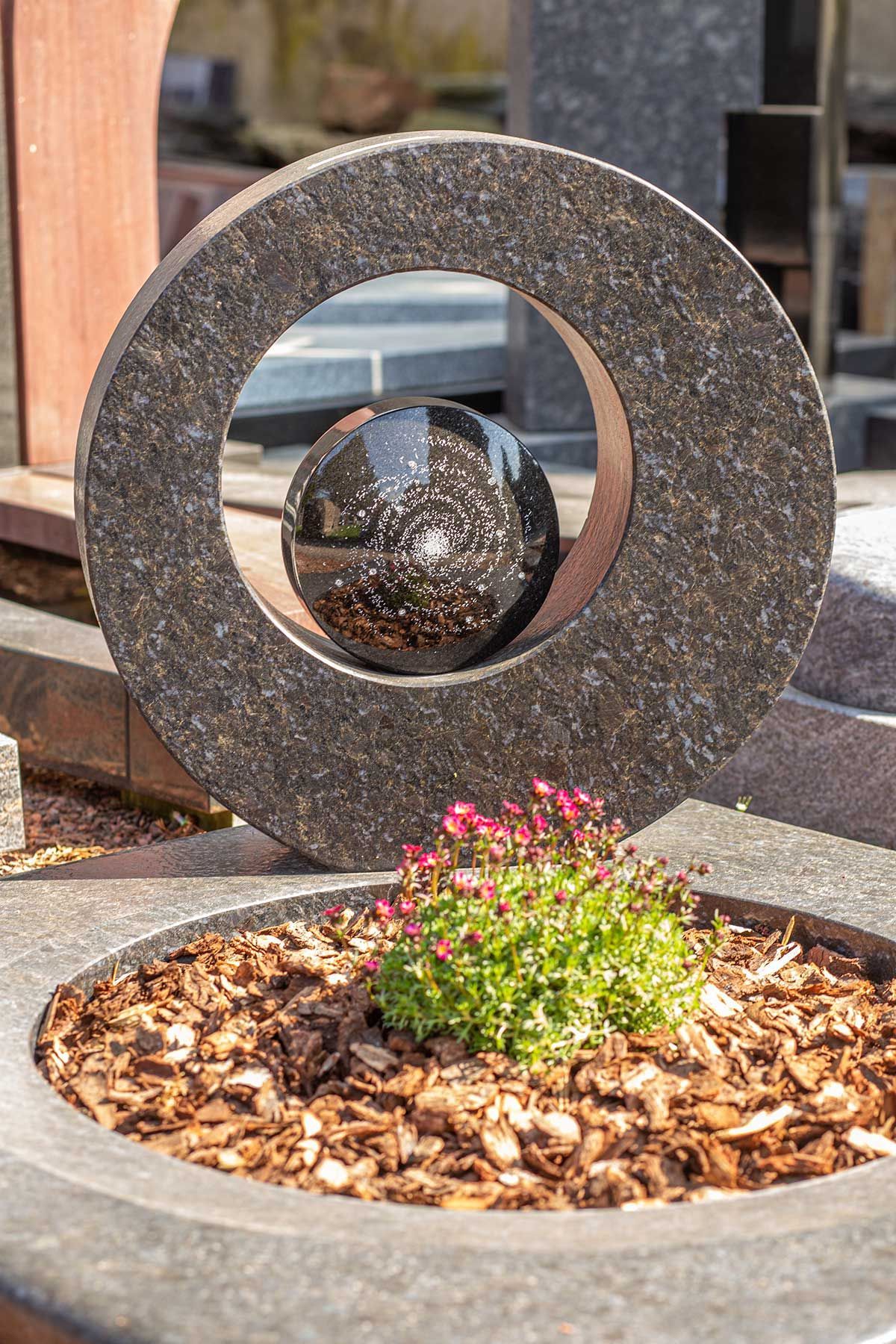 Runder Grabstein mit Kugelelement in der Mitte