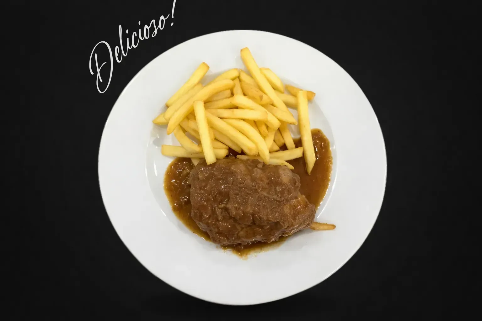 Plato con filete en salsa y patatas fritas sobre fondo negro.