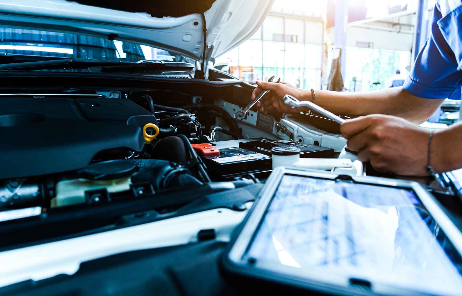 Mécanicien réalisant un contrôle technique sur un moteur de véhicule