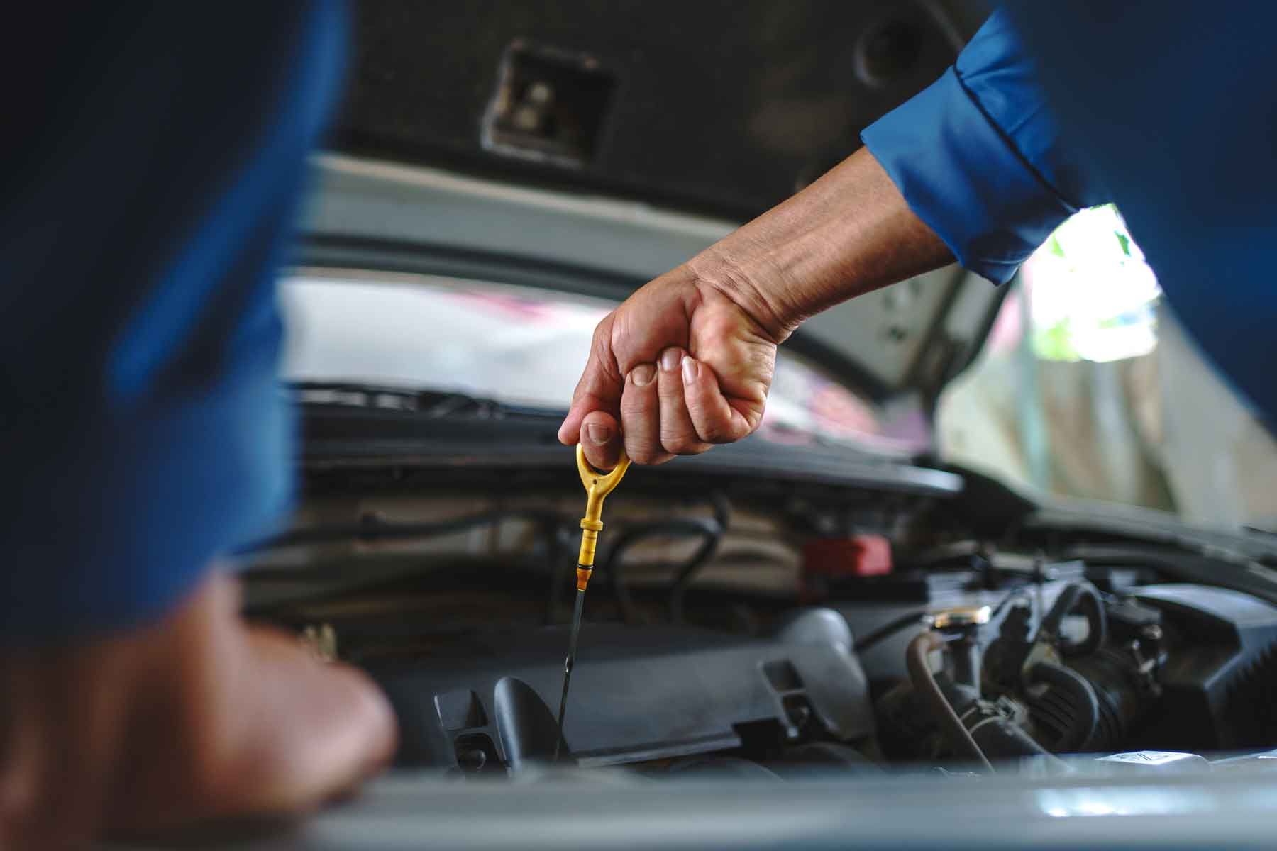 Mécanicien qui mesure le niveau d'huile d'un véhicule