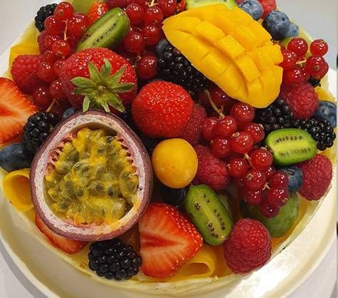 Tarte aux fruits colorée garnie de fraises, de mangue, de fruit de la passion, de kiwi, de framboises et de myrtilles
