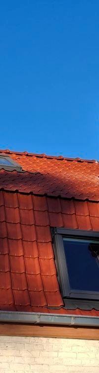 Un bâtiment en briques avec un toit de tuiles rouges.