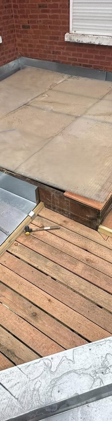 Bâtiment en briques au toit de tuiles rouges sous un ciel bleu.