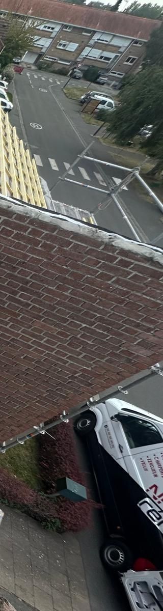 Ciel bleu avec un poteau électrique et un bâtiment dans un cadre herbeux.