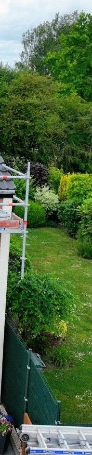 Ciel bleu avec un poteau électrique et un bâtiment dans un cadre herbeux.