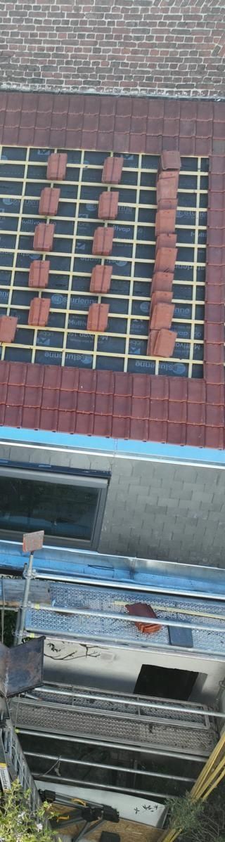 Maison en briques au toit de tuiles rouges.